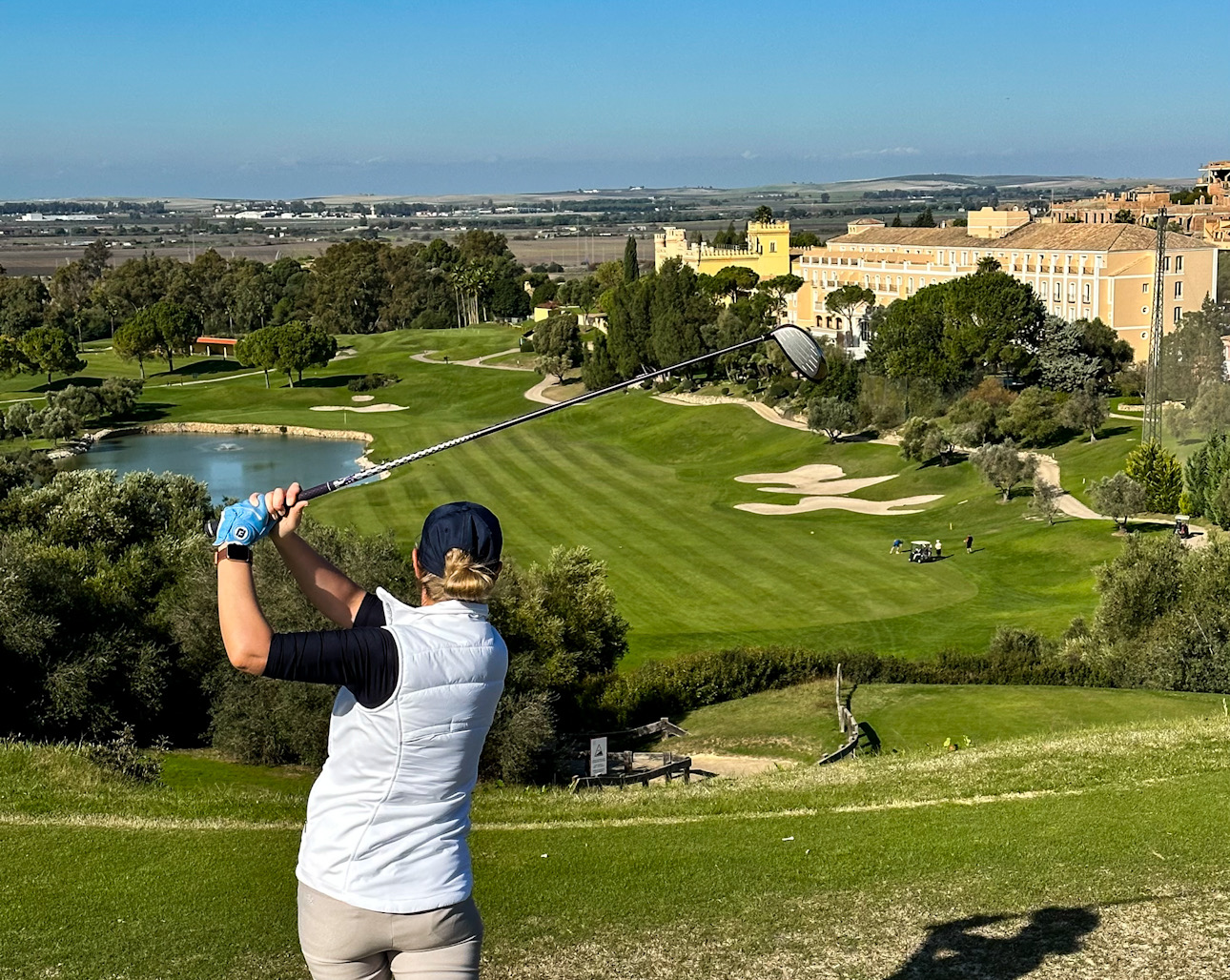 Golferin beim Abschlag am 18. Loch mit Blick über den Golfplatz Montecastillo Richtung Jerez