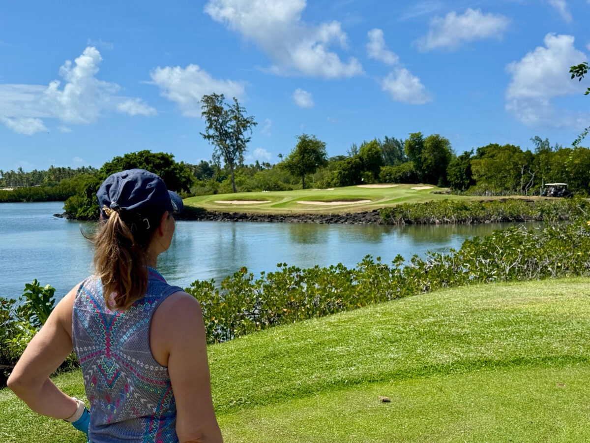 Golferin mit Blick auf Wasserhindernis auf das Inselgrün