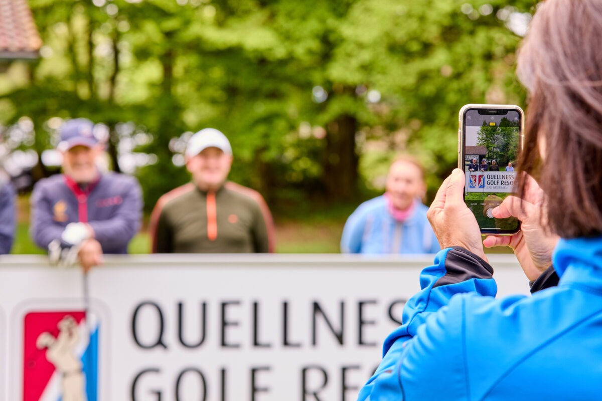 Person fotografiert Golfveranstaltung im Freien