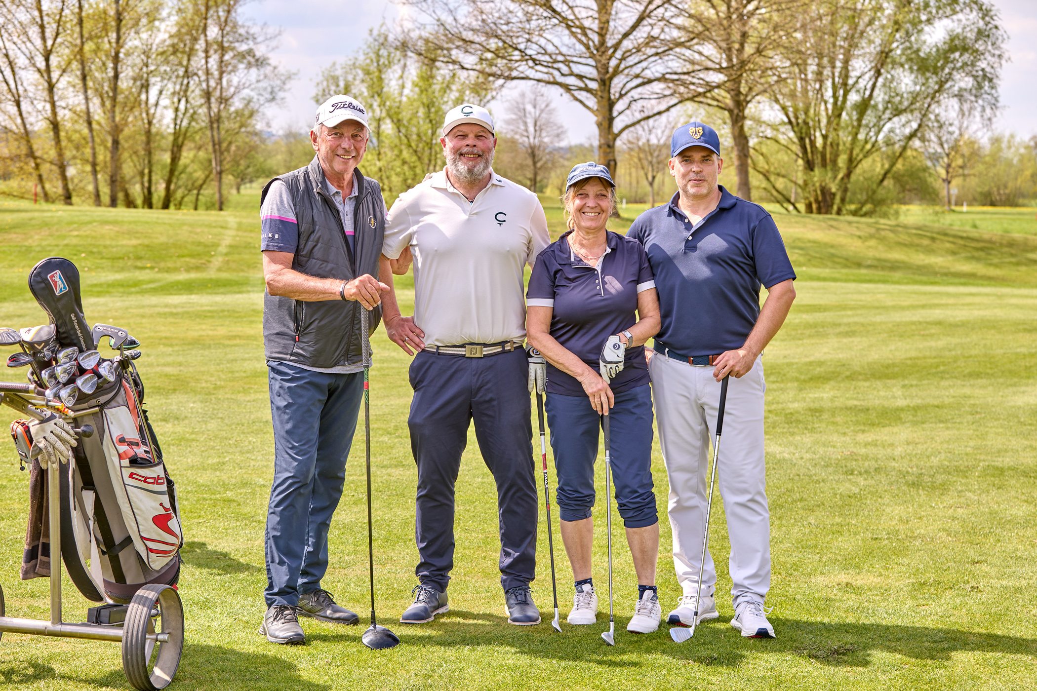 Vier Golfer auf einer Golfbahn.