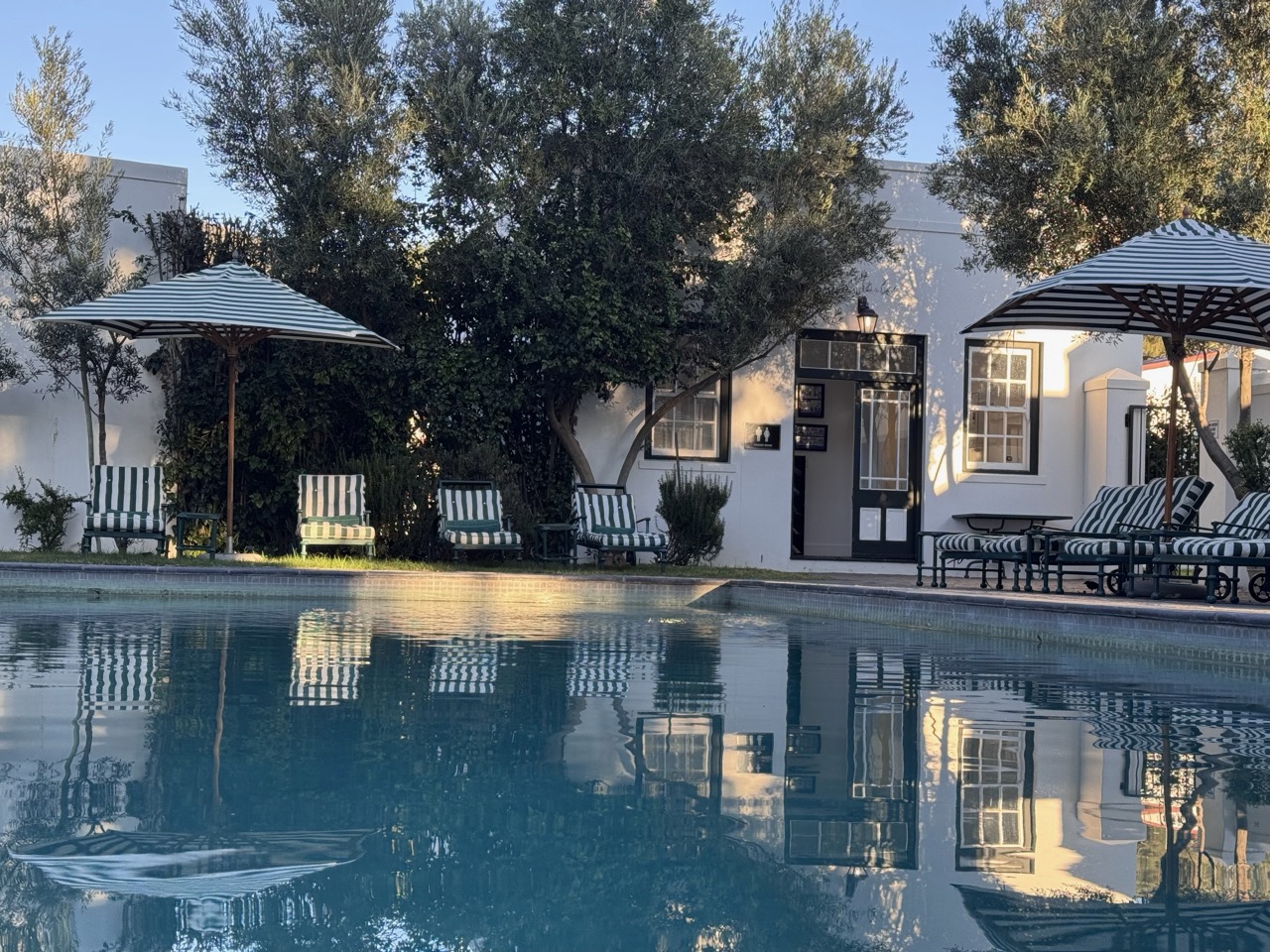 Schöner Pool mit Liegen und Sonnenschirmen