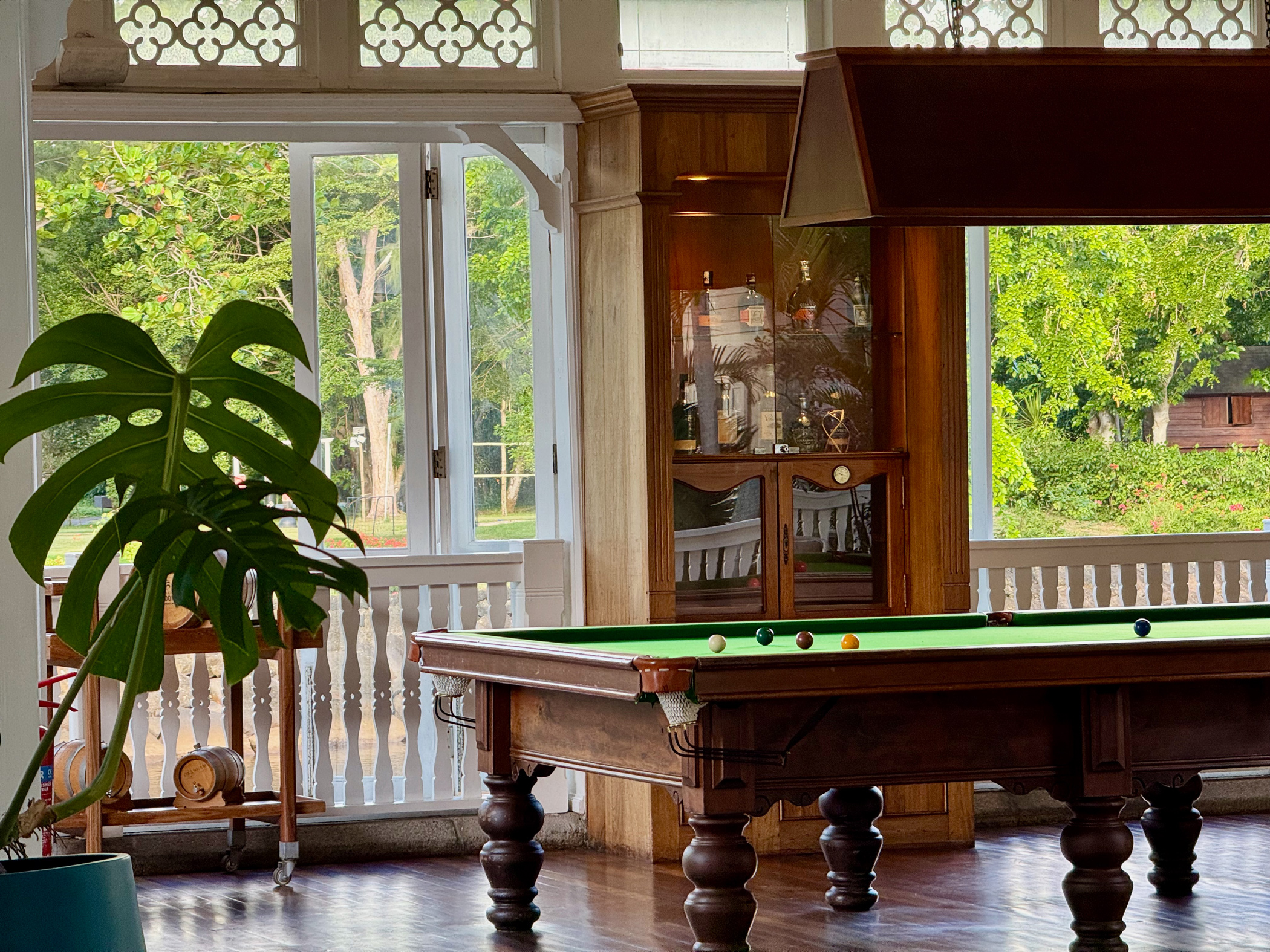 Billardtisch im eleganten Wohnbereich mit dunkler Kolonialarchitektur