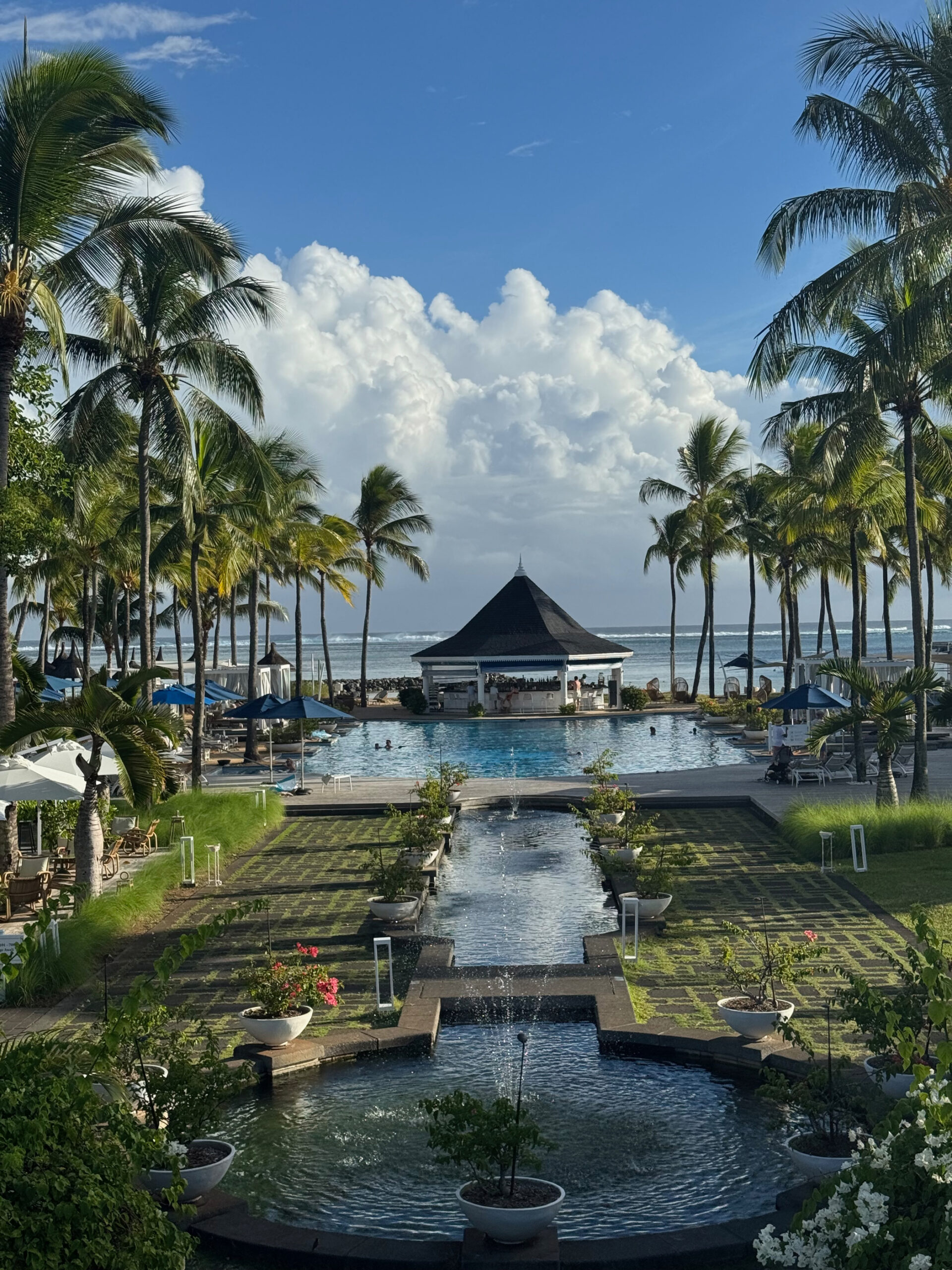 Poollandschaft im Heritage Le Telfair Mauritius bei Nacht mit Palmen und Lichtern