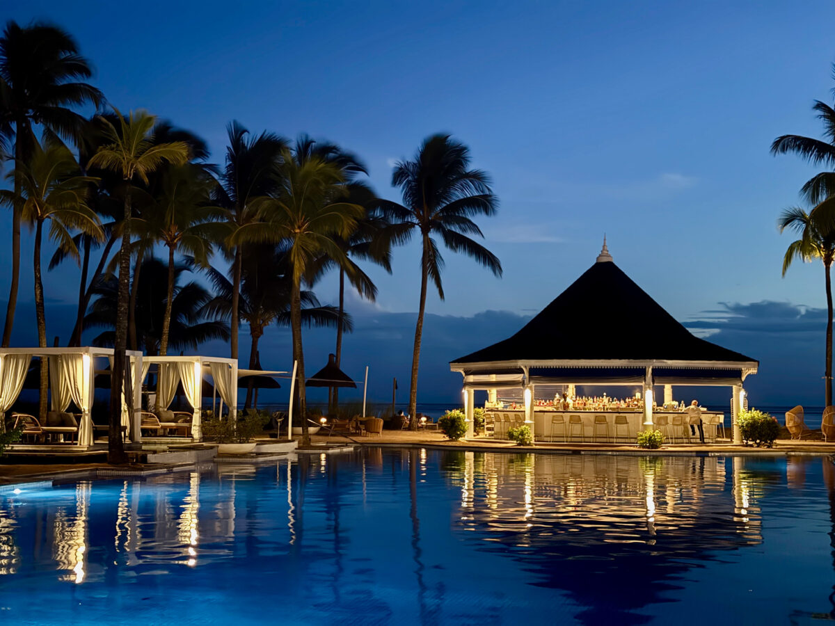 Beleuchteter Pool im Heritage Le Telfair Mauritius bei Nacht mit Palmenkulisse