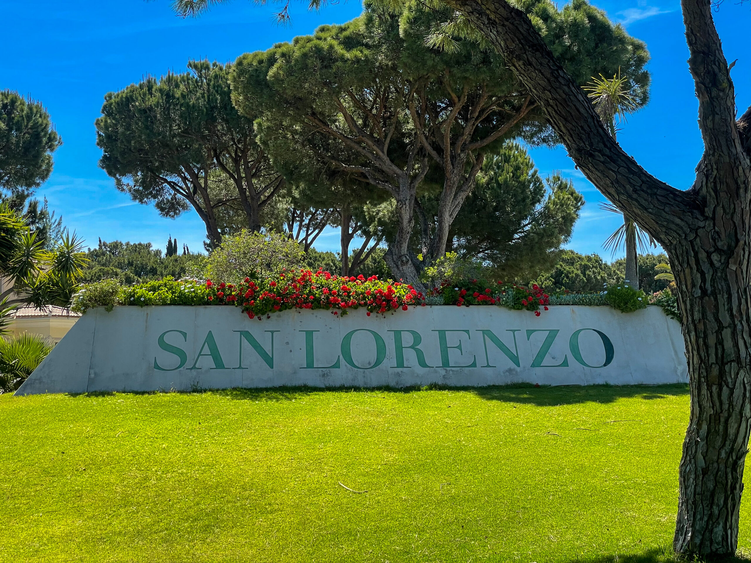 Eingangsbereich des San Lorenzo Golf Club an der Algarve mit gepflegtem Grün und Pinien