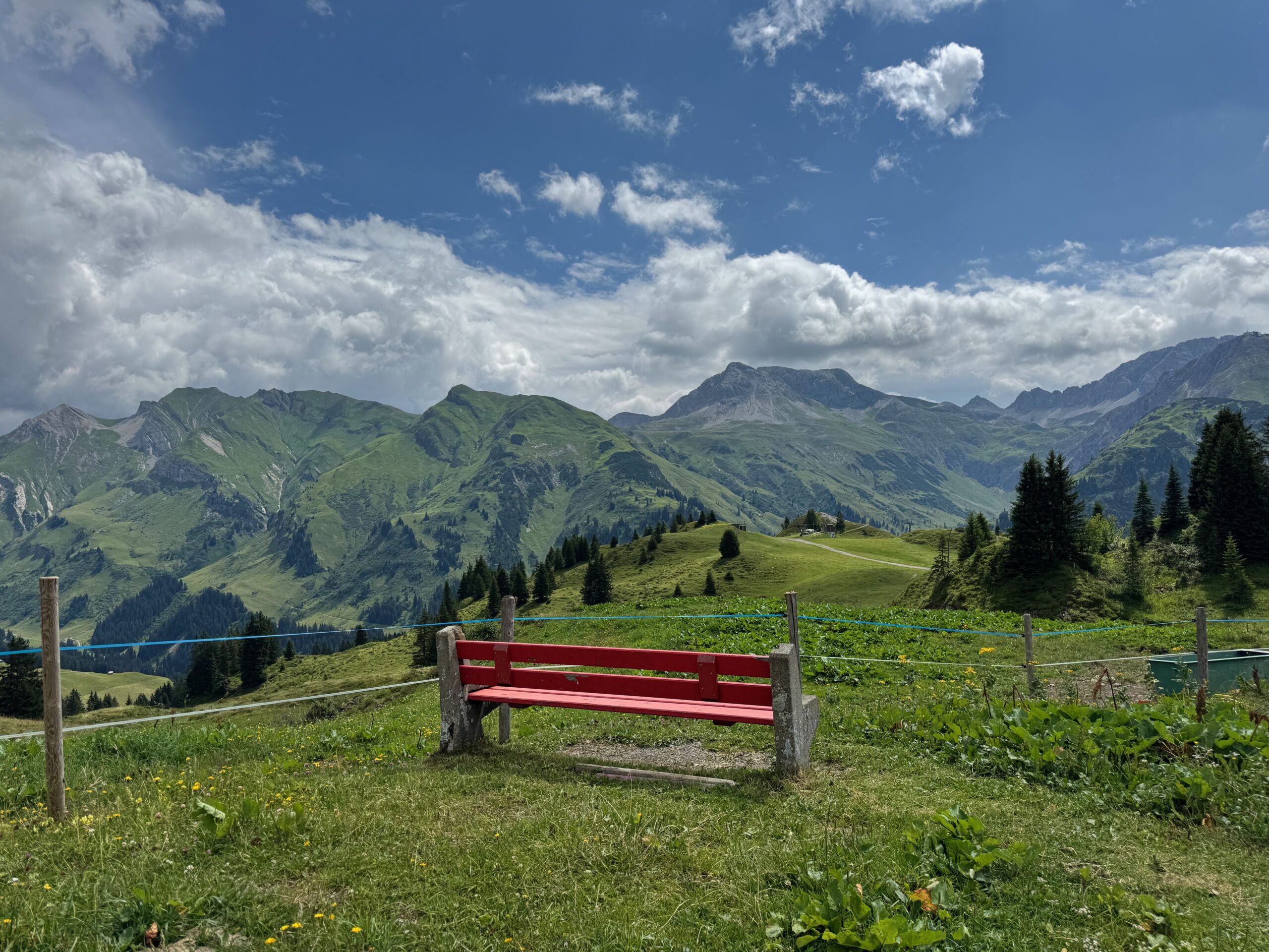 Rote Bank mit Bergblick und Wolken
