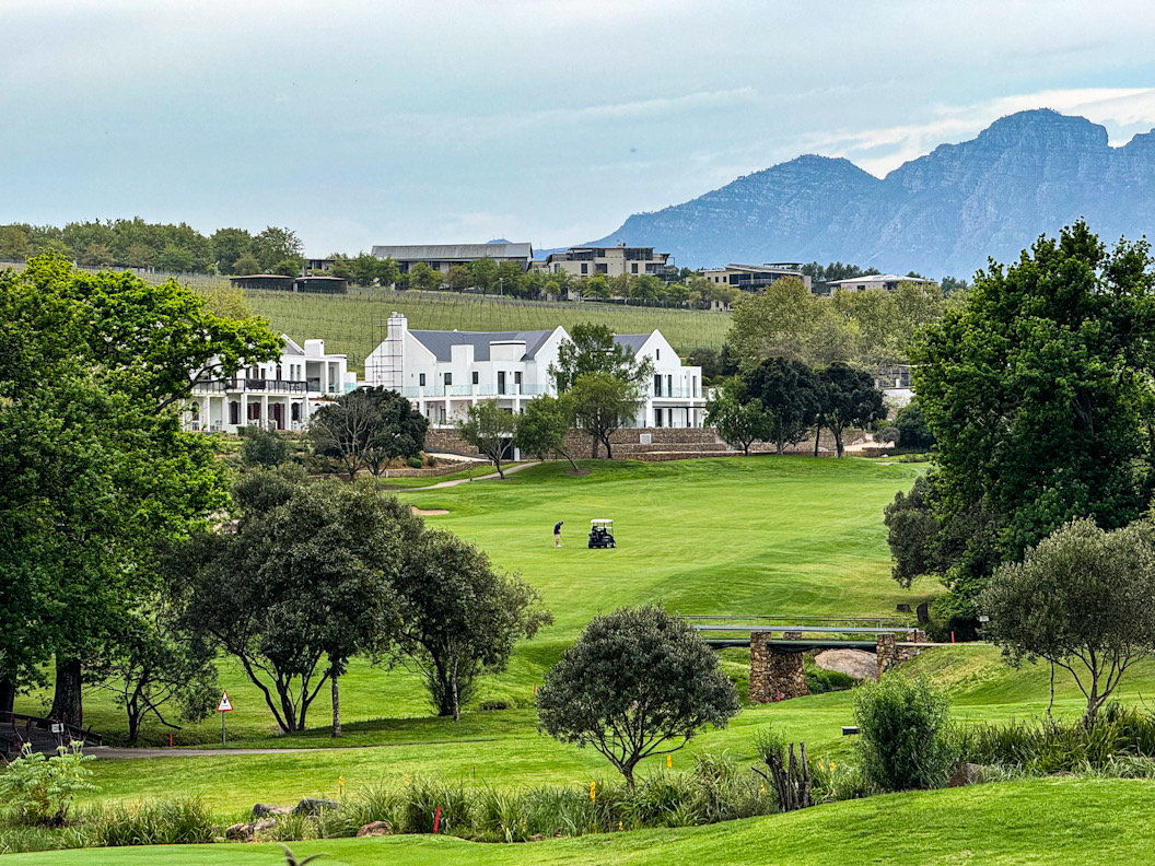 Fairway mit weissen Häusern und Bergkulisse