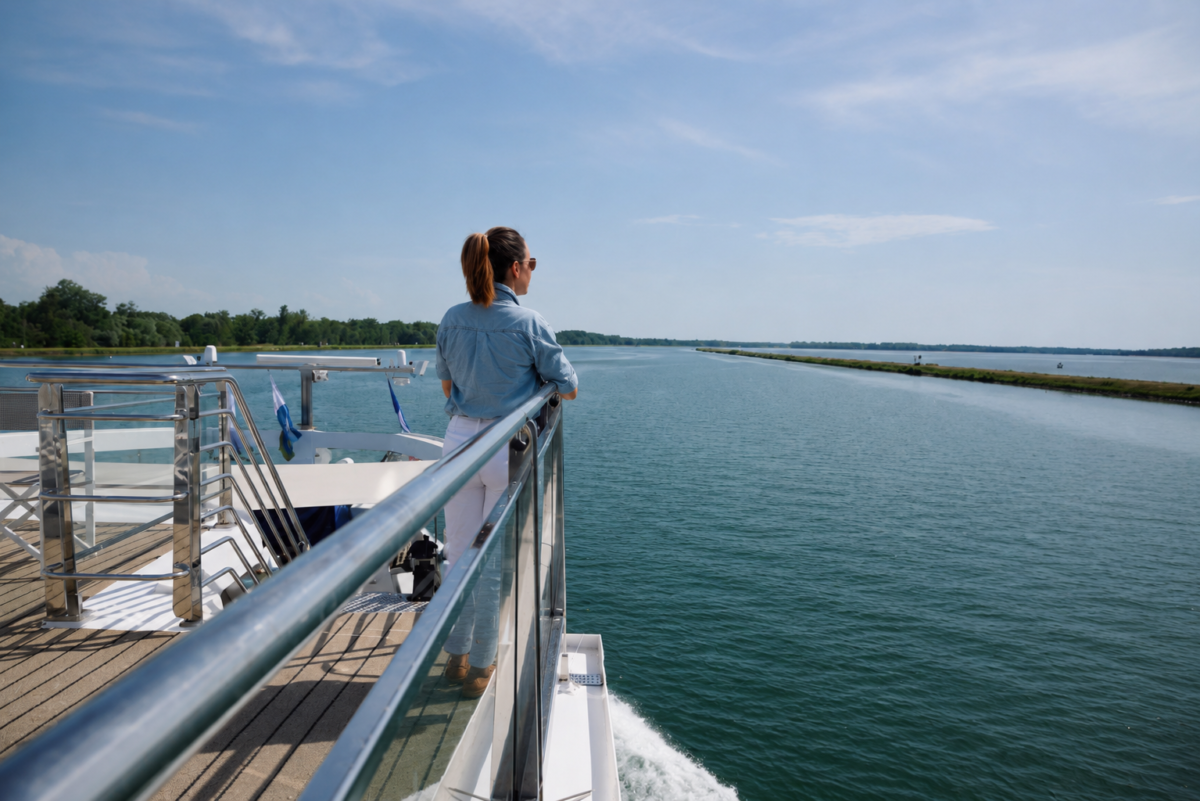 Frau schaut auf ruhigen Fluss.