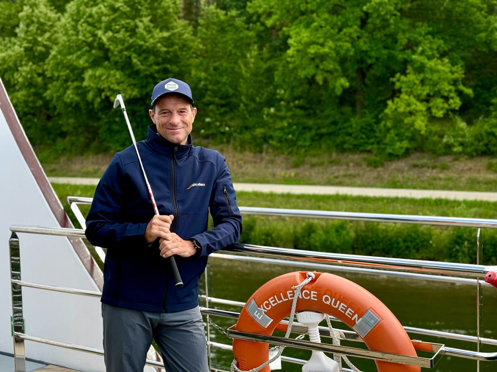 Mann mit Golfschläger auf Schiff