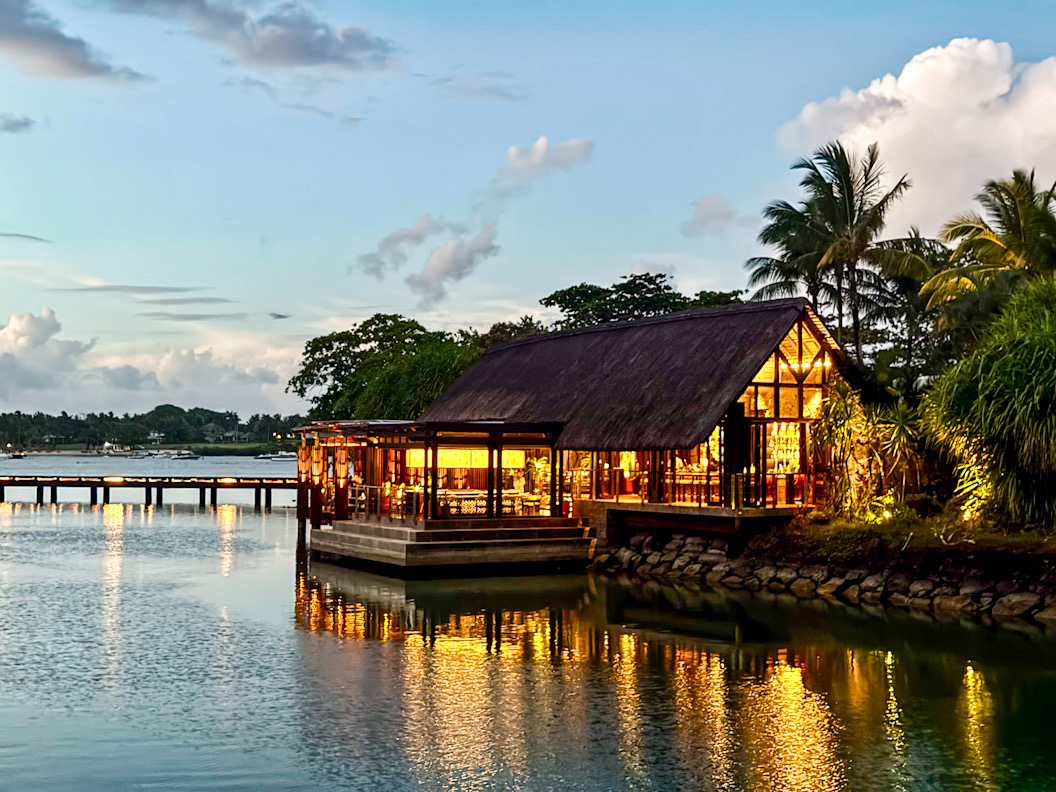 Tropisches Resort am Wasser bei Sonnenuntergang