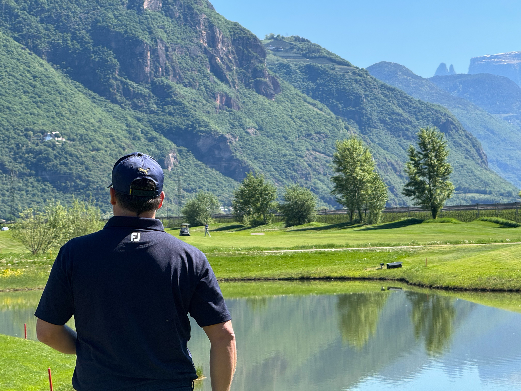 Mann am Golfplatz mit Bergen
