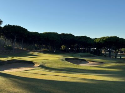 Golfplatz mit Bunkern und Bäumen im Sonnenlicht