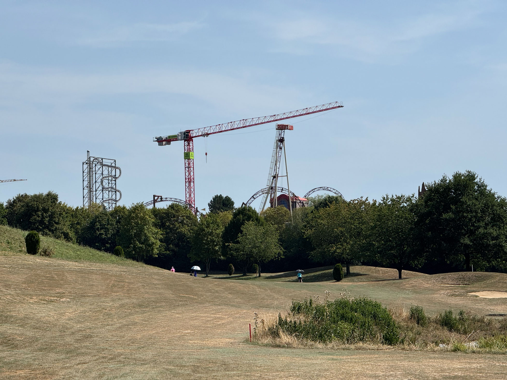 Golfplatz mit Achterbahn im Hintergrund