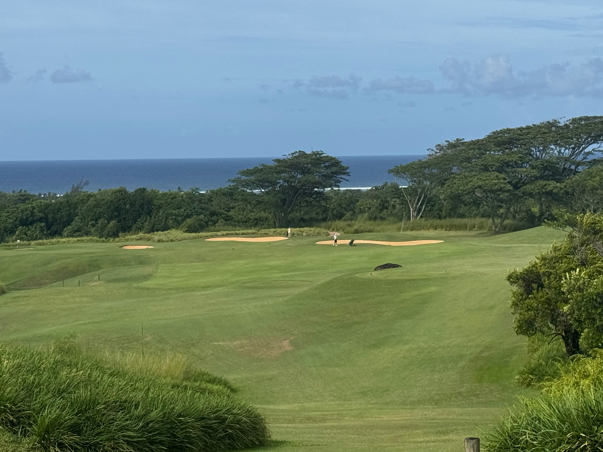 Blick auf Green am Le Château Golf Course Mauritius mit Ozean im Hintergrund