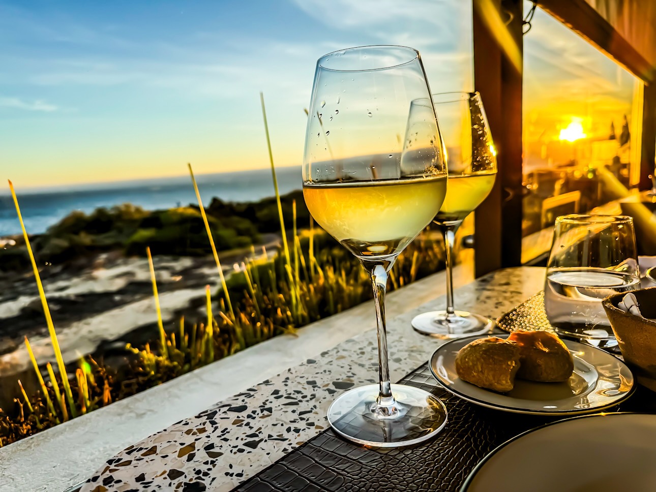 Wein und Sonnenuntergang am Meer