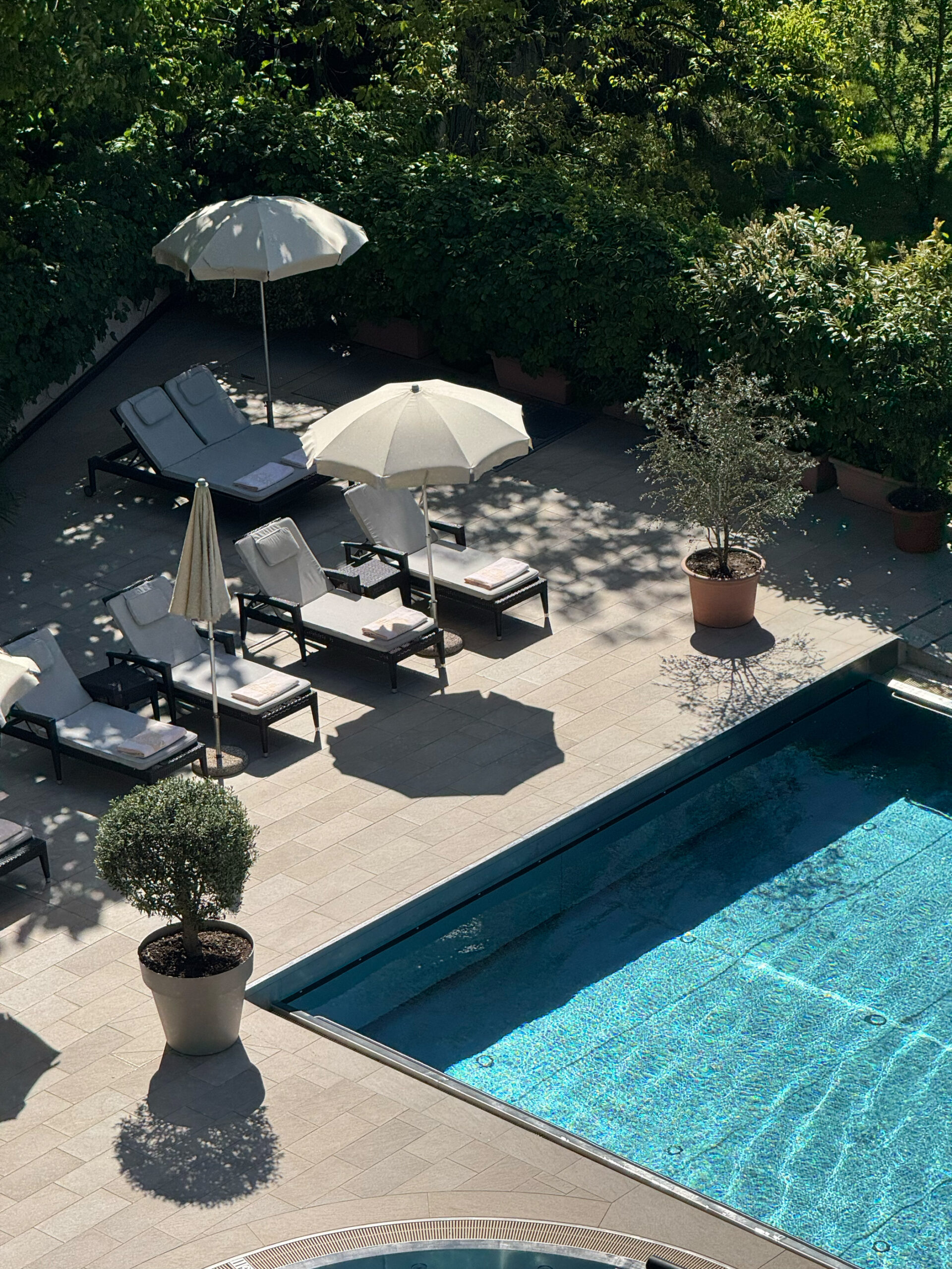 Schwimmbad mit Liegen und Sonnenschirmen