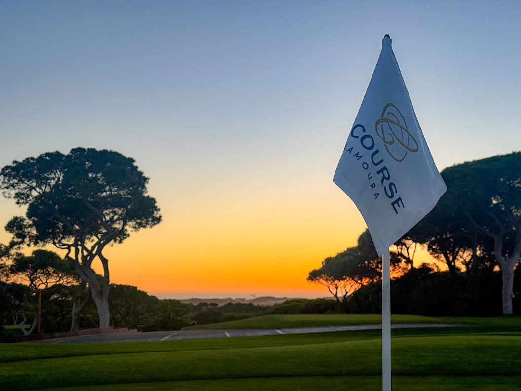 Golfplatz mit Sonnenuntergang im Hintergrund