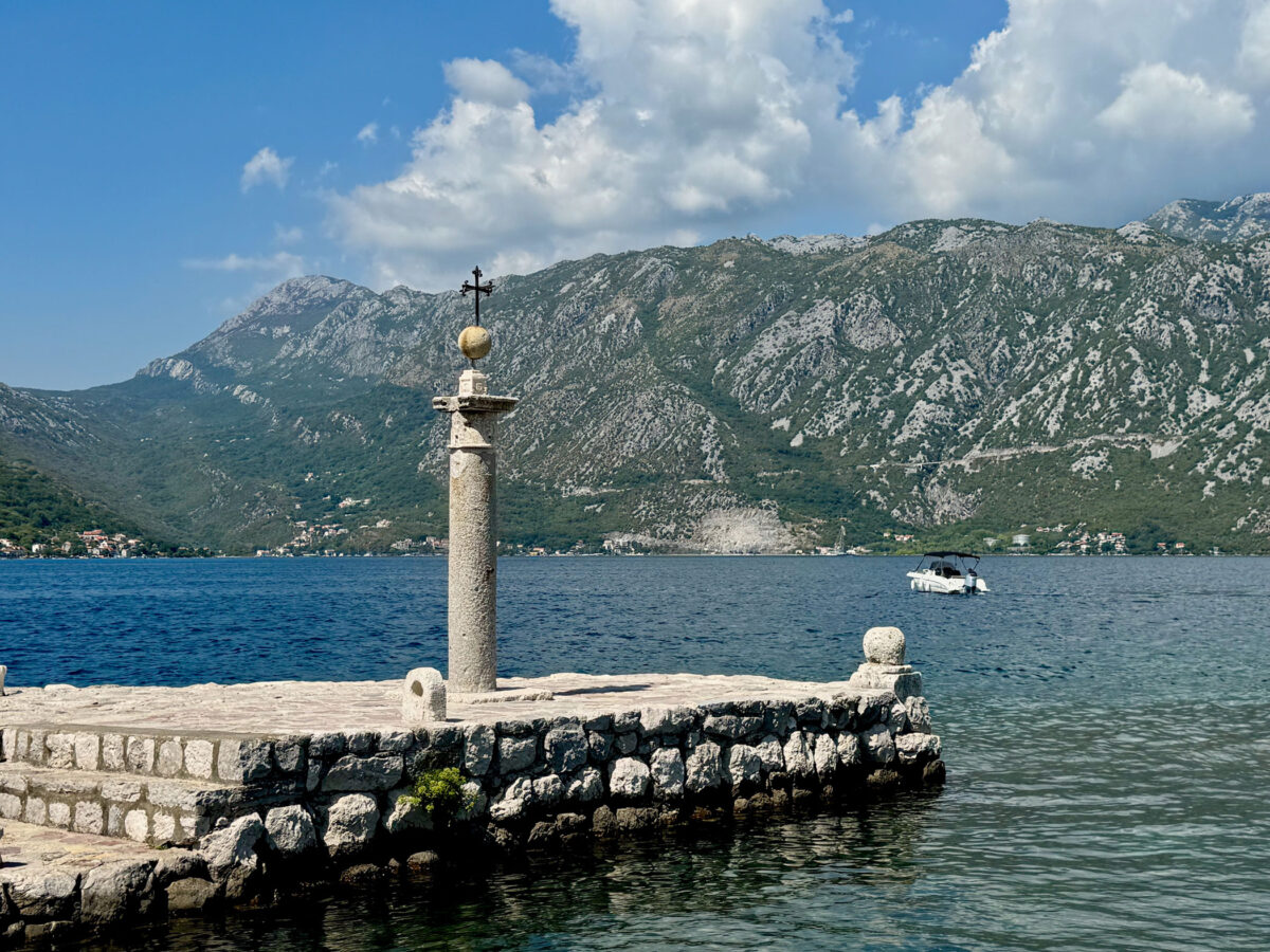 Steg am Wasser mit Bergen im Hintergrund