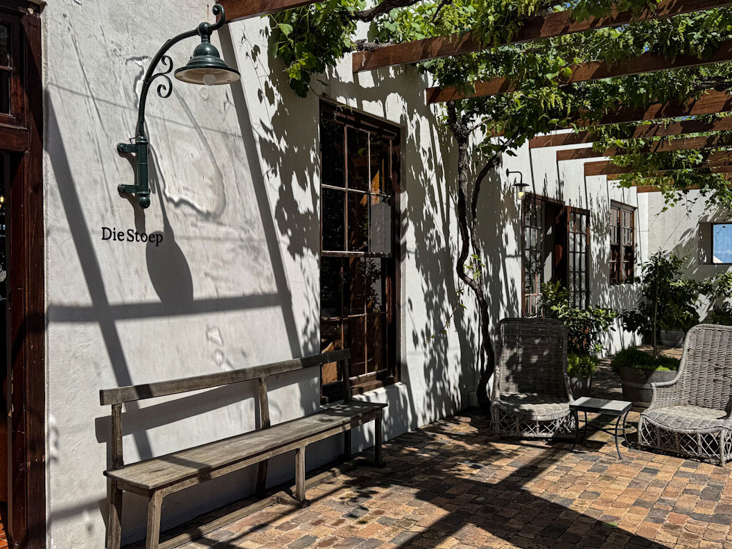 Helles Restaurant mit Schatten und Pflanzen.