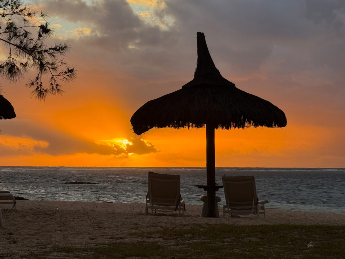Sonnenschirm und Meer bei Sonnenaufgang im Long Beach Mauritius