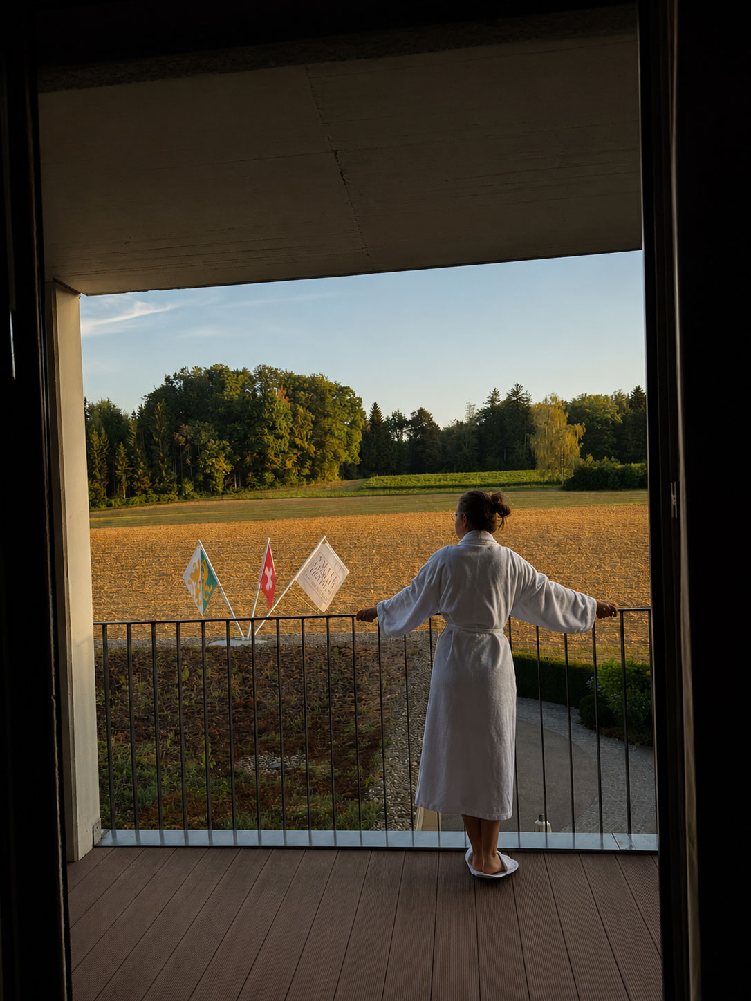 Frau auf Balkon mit Blick ins Grüne.